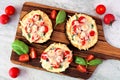 Eggplant mini pizzas on a serving board against marble