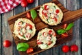 Eggplant mini pizzas on serving board against rustic wood