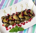 Eggplant rolls with nuts. Delicious starter of fried aubergines with nuts, herbs and pomegranate seeds Royalty Free Stock Photo