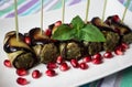 Eggplant rolls with nuts. Delicious starter of fried aubergines with nuts, herbs and pomegranate seeds Royalty Free Stock Photo