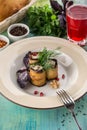 Eggplant rolls stuffed with cottage cheese and walnuts and glass of red drink on blue wooden table