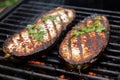 eggplants with charring marks on a grill, white smoke around Royalty Free Stock Photo