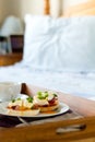 Eggs Benedict on breakfast tray on bed Royalty Free Stock Photo