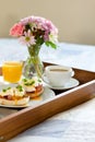 Eggs Benedict on breakfast tray on bed Royalty Free Stock Photo