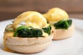 Eggs benedict or eggs florentine on a white plate in the cafe