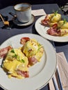 Eggs Benedict with ham, topped with hollandaize sauce and served with coffee at a brunch Royalty Free Stock Photo