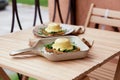 Eggs benedict with plant-based sauce, sourdough bread, tofu, young onion, greens, pea sprouts. Vegan dish. Healthy Royalty Free Stock Photo