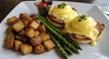 Eggs benedict with potatoes and asparagus plate Royalty Free Stock Photo