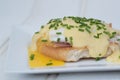 Eggs Benedict toasted English muffins ham poached eggs and hollandaise sauce