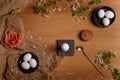 Eggs in black bowls and egg cup with silver spoon, salt pot, fabric rose flower and cherry blossom on sackcloth Royalty Free Stock Photo