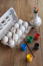 Eggs in a box, colored paint, brush and pencils. Royalty Free Stock Photo