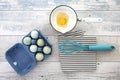 Eggs in a box with a whisk on a rustic wood table Royalty Free Stock Photo