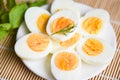 Eggs breakfast, fresh eggs menu food boiled eggs in a white plate decorated with leaves green dill background, cut in half egg