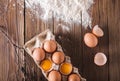 Eggs and broken eggs in the package on a wooden background. Were scattered flour on a wooden table. Eggshell. Baking Royalty Free Stock Photo