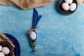 Eggs on brown paper and blue plate. Easter bunny made from egg and polka dot napkin ears in silver egg cup Royalty Free Stock Photo