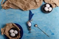 Eggs on brown paper and blue plate. Easter bunny made from egg and polka dot napkin ears, spoon, silver egg cup Royalty Free Stock Photo