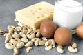 Eggs, cheese, nuts, glass of milk on grey background