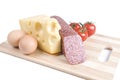 Eggs, cheese, sausage and tomatoes on a board Royalty Free Stock Photo