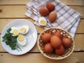 Eggs cut on a plate, in the basket and on the kitchen towel on a wooden table, rustic styl