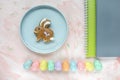 Eggs decoration, bunny cookie and notebook on pink