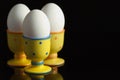 Eggs in dotted eggcups on black Royalty Free Stock Photo