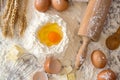 Eggs, dough, flour and rolling-pin baking cakes on wooden table Royalty Free Stock Photo