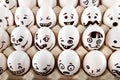 Eggs with drawn cartoon faces in tray.