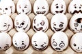 Eggs with drawn cartoon faces in tray.