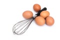 Eggs and eggbeater on white background