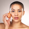 Eggs have so many beauty benefits. Studio shot of a beautiful young woman holding a egg against her face. Royalty Free Stock Photo