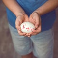 Eggs with the inscription Happy Easter the child holds in her hands in front of him