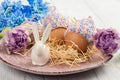 Eggs in knitted hats, flowers and decorative rabbit