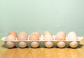 Eggs laid in plastic tray, wooden background Royalty Free Stock Photo