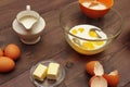 Eggs with milk and other necessary ingredients for making dough for baking on wooden table Royalty Free Stock Photo