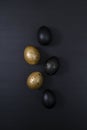 Eggs painted gold and black on dark background. Minimal Easter concept Royalty Free Stock Photo