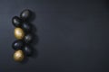 Eggs painted gold and black on dark wooden background. Minimal Easter concept. Luxury backdrop Royalty Free Stock Photo