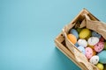 Eggs painted in a wooden box on a blue background. Copy space for text. Easter card. Royalty Free Stock Photo