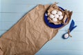 Eggs on paper and blue plate. Easter bunny made from egg and polka dot napkin ears on wooden blue background. Easter concept Royalty Free Stock Photo