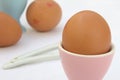 Eggs in pink and blue egg cups on a table in shallow focus