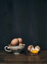 Eggs in porcelaine cup with cracked egg beside on vintage table Royalty Free Stock Photo