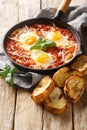 Eggs in Purgatory is an easy Italian dish served with lots of crusty bread for dipping closeup. Vertical