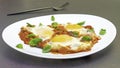 `Eggs in Purgatory`, a traditional Mediterranean breakfast dish of eggs poached over a spicy tomato sauce topped with melted chees