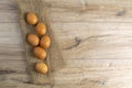Eggs stand on a burlap that stands on a brown wooden table Royalty Free Stock Photo