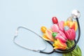 Eggs with stethoscope and flowers on blue background. copy space , medicine easter Royalty Free Stock Photo