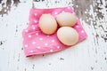 Eggs on tablecloth over wooden background