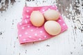 Eggs on tablecloth over wooden background