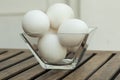 Eggs in a transparent glass bowl isoated on wooden table. Royalty Free Stock Photo
