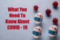 Eggs wearing medical mask for stop coronavirus and models of covid-19 virus on blue background