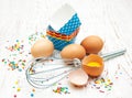 Eggs, whisk and cupcake liners Royalty Free Stock Photo