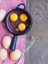 Eggs and whisk on wooden background